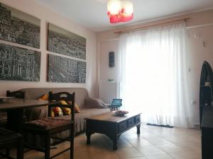 een woonkamer met een bank, een tafel en een raam bij Fanari summer house 2 floors in Fanárion