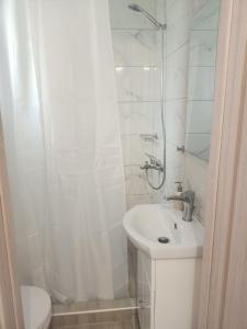 bagno bianco con lavandino e doccia di ALMIRIKI Studios & Apartments a Alykes
