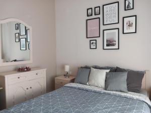 1 dormitorio con 1 cama y cuadros enmarcados en la pared en Fanari summer house 2 floors, en Fanárion