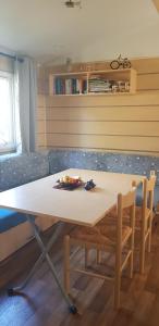 a table and chairs in a room with a couch at Splendide mobil-home in Narbonne