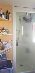 a shower with a glass door in a bathroom at Splendide mobil-home in Narbonne