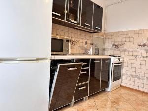 a kitchen with brown cabinets and a white refrigerator at Apartament Dąbrowskiego - Gliwice in Gliwice +8 photos