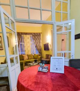 Zimmer mit einem Tisch und einem roten Tischtuch in der Unterkunft Liora's Place in Korçë