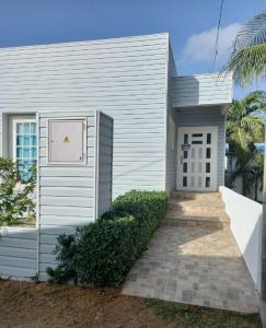 a white house with a pathway in front of it at Holiday Loft Suite Apartamento in San Andrés