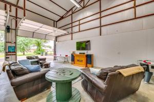 a living room with couches and a table at Spacious Lake Texoma Vacation Rental with Game Room! in Kingston