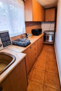eine Küche mit Holzschränken, einem Waschbecken und einem Fenster in der Unterkunft Liora's Place in Korçë