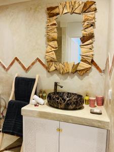 a bathroom with a sink and a mirror on a counter at Riad Tsar Mimoun in Marrakesh