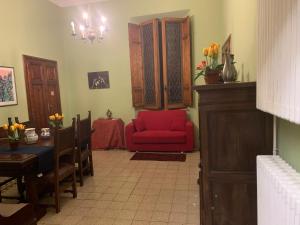 a living room with a red chair and a table at CASA BENVENUTI in Pisa