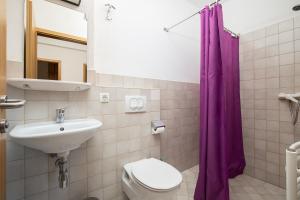 y baño con lavabo y cortina de ducha púrpura. en Apartments Ivan mit Meerblick en Pomer