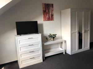 a bedroom with a dresser with a television on it at Pension Drei Rosen in Karlovy Vary +18 photos