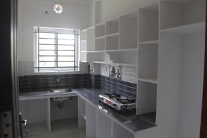 a white kitchen with a sink and a window at CITY APARTMENTS in Guruvāyūr
