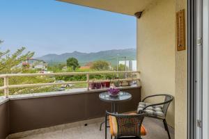 a balcony with a table and chairs and a view at Apartment Zara with Free parking in Dugopolje