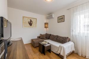 a living room with a couch and a tv at Apartment Zara with Free parking in Dugopolje