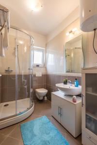 a bathroom with a shower and a sink and a toilet at Apartment Zara with Free parking in Dugopolje