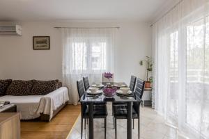 a living room with a table and chairs and a couch at Apartment Zara with Free parking in Dugopolje