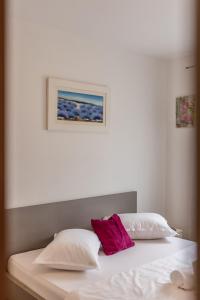 1 cama con 2 almohadas y una foto en la pared en Apartment Zara with Free parking en Dugopolje