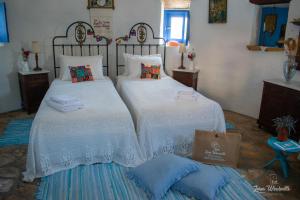 1 dormitorio con 2 camas y toallas. en Leros Windmills, en Panteli