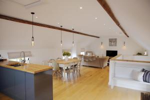 cocina y sala de estar con mesa y comedor en The Barn @Bourne Eau House, en Bourne