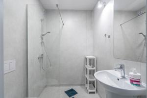 biała łazienka z prysznicem i umywalką w obiekcie PIONOW Pokoje Hotelowe - adults only w mieście Krynica Morska