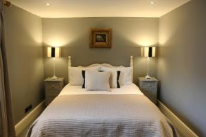 een slaapkamer met een groot bed met twee nachtkastjes bij The Barn @Bourne Eau House in Bourne +7 foto's