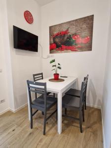 een eetkamer met een witte tafel en stoelen bij La casa di Eurialo in Rome