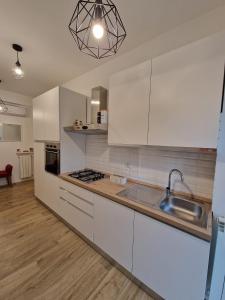 a kitchen with white cabinets and a sink at La casa di Eurialo in Rome