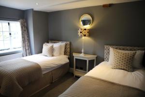 a bedroom with two beds and a mirror on the wall at The Barn @Bourne Eau House in Bourne