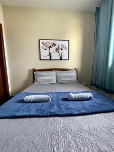 Una cama con sábanas azules y dos almohadas. en Hope Hostel Guarapari, en Guarapari