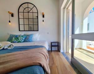 - une chambre avec un lit et une grande fenêtre dans l'établissement Vila Arvela, à Albufeira