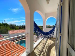 d'un balcon avec un hamac et une piscine. dans l'établissement Vila Arvela, à Albufeira