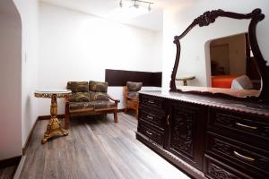 1 dormitorio con tocador con espejo y silla en Hotel Monasterio del Inka, en Cusco
