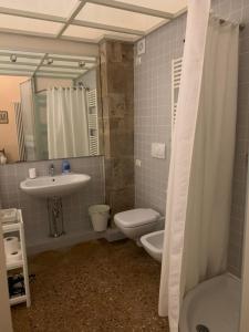 a bathroom with a sink and a toilet and a mirror at CASA BENVENUTI in Pisa