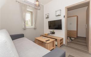 ein Wohnzimmer mit einem Sofa und einem Flachbild-TV in der Unterkunft Beautiful Apartment In Sibenik With Wifi in Šibenik