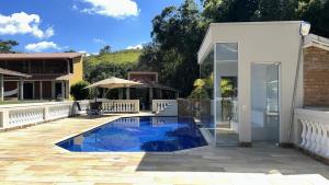 una piscina in un cortile accanto a una casa di Refúgio espiritual e total conforto nas montanhas a Caldas