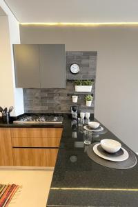 a kitchen with a black counter top with a stove and a counter sidx sidx sidx at Amerittania 402 in Guadalajara
