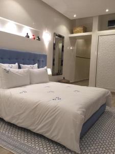 Schlafzimmer mit einem großen Bett mit blauem Kopfteil in der Unterkunft Riad Tsar Mimoun in Marrakesch