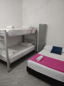 1 dormitorio con 2 literas y manta morada en Hostal 1811, en Cartagena de Indias