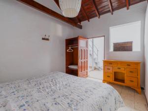 a bedroom with a bed and a dresser and a window at FAMILY COTTAGE AMONG OLIVE TREES in Agüimes