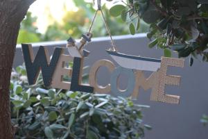 a sign hanging from a tree with the word welcome at Casa d' Avó Zeza in Jardim do Mar
