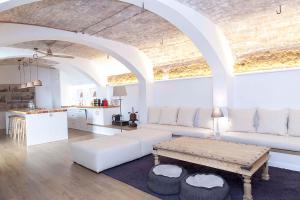 een woonkamer met een witte bank en een tafel bij A historic XVI century beach home near Barcelona in Barcelona
