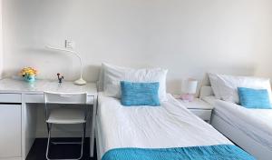 a bedroom with a bed and a desk with blue pillows at YingYing Apartamento with a free parking space in Lisbon