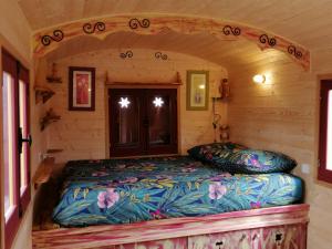 a bed in a small room in a log cabin at Balad'âne in Flachères