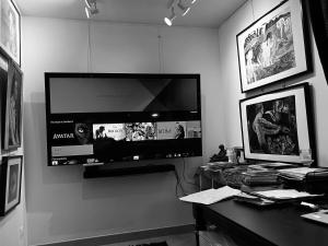 biurko z monitorem i komputerem na ścianie w obiekcie Atelier d artiste 