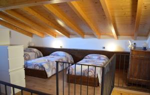 2 bedden in een kamer met houten plafonds bij Balcony on Lake Pianello in Pianello Del Lario