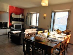 Pianello Del LarioにあるBalcony on Lake Pianelloのテーブルと椅子のあるキッチンとリビングルーム