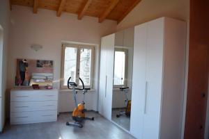 een kamer met een loopband, een dressoir en een spiegel bij Balcony on Lake Pianello in Pianello Del Lario