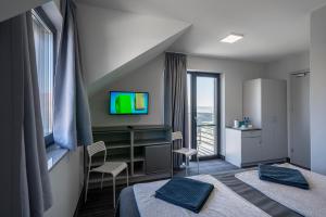 pokój hotelowy z dwoma łóżkami i telewizorem w obiekcie PIONOW Pokoje Hotelowe - adults only w mieście Krynica Morska