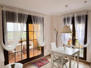 ein weißes Esszimmer mit einem Tisch und einem Fenster in der Unterkunft APTO. DE 1 DORMITORIO EN PRIMERA LINEA DE PLAYA. ISLA CANELA in Huelva
