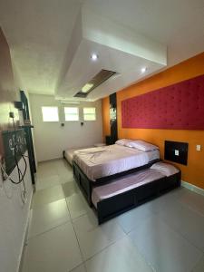 1 dormitorio con 2 camas y pared roja en Isla cuba en Acapulco