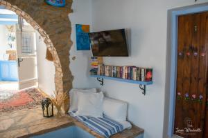 a living room with a tv on a wall at Leros Windmills in Panteli